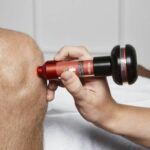 Profesional aplicando el láser terapéutico Energy Laser L500 Pro sobre el hombro de un paciente