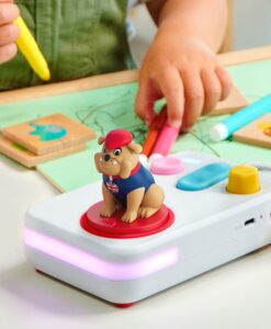 Mano de un niño con un rotulador junto al cuentacuentos FABA+ y la figura del bulldog de canciones en inglés