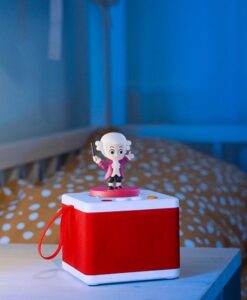 Cuentacuentos FABA rojo con la figura de Mozart junto a una cuna, con luz azul de noche