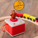 Red FABA children's storytime set featuring The Gruffalo, on a wooden floor next to a toy train