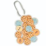Pinzas del juego sobre un montón de galletas con pepitas y galletas glaseadas con letras