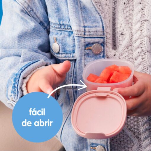 Manos de un niño abriendo un depósito hermético b.box rosa sin ayuda de un adulto