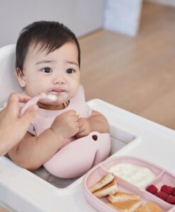 Niño comiendo en la trona con el plato con ventosa b.box fijado a la bandeja