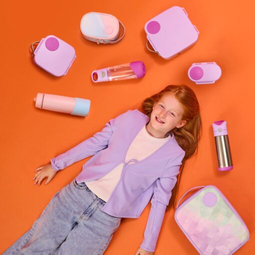 Niña alrededor de productos b-box con fondo naranja y botellas y tuppers de color rosa