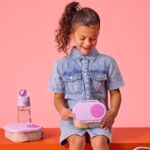 Niña con mochila llevando la fiambrera de snacks b.box y una botella a juego