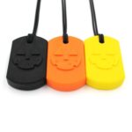 Los tres colores del collar mordedor Calabaza de ARK en fila: negro, naranja y amarillo