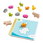Bao's Cloudland de HABA: los 12 animales de madera alrededor del cuaderno abierto