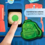 Hello, Vacation! de HABA: dedo girando el dado de colores junto a la mochila verde