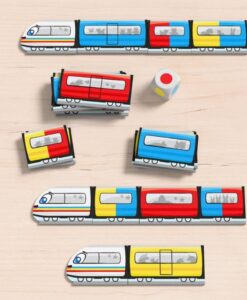 Color Express de HABA: locomotoras y vagones de colores sobre la mesa con el dado