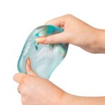 Cubo de azúcar squishy de Scrunchems: dos manos apretando y estirando el cubo azul