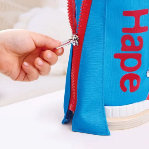 Zapatilla Tie-It de Hape: mano abriendo la cremallera del lateral, para aprender a atar los cordones