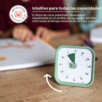 Time Timer MOD Home Edition verde sobre la mesa mientras un niño escribe en su cuaderno al lado