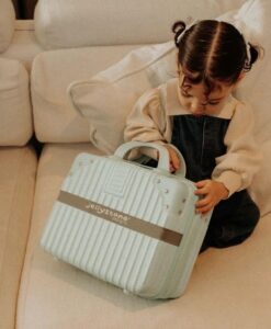 Maleta Big Feelings de Jellystone: niña abriendo la maleta azul sentada en el sofá