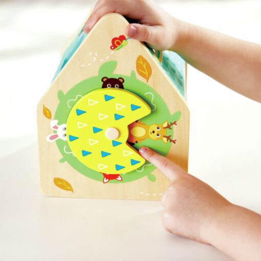 Clasificador Casa de Criaturas de Hape: manos girando la rueda lateral de colores que descubre a los animales