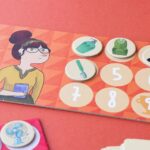 Juego Where are my socks? de Londji: tablero de una mujer con gafas con fichas sobre los números