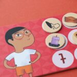 Juego Where are my socks? de Londji: tablero de un niño con gafas con fichas sobre sus números