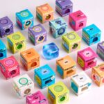 Fun Cube de J'adore: cinco cubos de colores sobre sus cajas con la ventana del envase