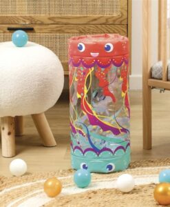 Baby Roller Medusa de Ludi: el rulo de pie junto a un puf en una habitación con bolas de colores