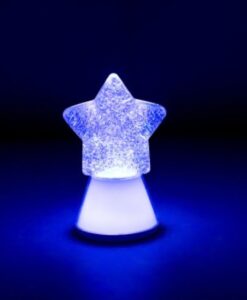 Lámpara estrella Magic Glow Little L: estrella encendida en blanco y azul con la purpurina girando sobre fondo oscuro