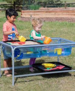Mesa sensorial de agua y arena Edx: dos niños jugando con agua en la mesa sensorial al aire libre