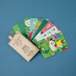 Puzzle de misterio de Londji: cartas de deducción verdes abiertas en abanico junto a su sobre