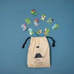 Puzzle de misterio de Londji: bolsa de tela con cordón de la que salen piezas del puzzle