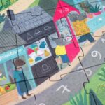 Puzzle de misterio de Londji: detalle de un puesto de sombreros con personajes y la forma de las piezas