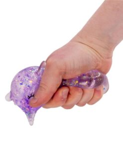Unicornio squishy Sugar Unicorn: mano estrujando el unicornio morado, que se deforma con la purpurina