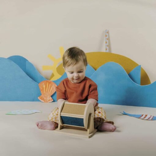 Sensory Roller de Petit Boum: bebé tocando el rodillo con las dos manos, rodillo sensorial de madera