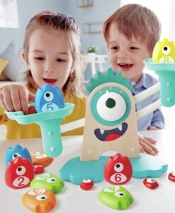Báscula matemática Monstruosa de Hape: dos niños poniendo monstruos numerados en los platillos de la báscula