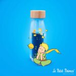 Botella sensorial El Principito de Petit Boum: botella sobre fondo azul con el dibujo del Principito