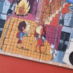 Puzzle Enchanted de Londji: detalle de dos niños con mochila en un pasillo con escaleras
