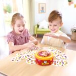 Zunk de Hape, juego de rapidez: niña y niño jugando a Zunk en la mesa con las cartas repartidas